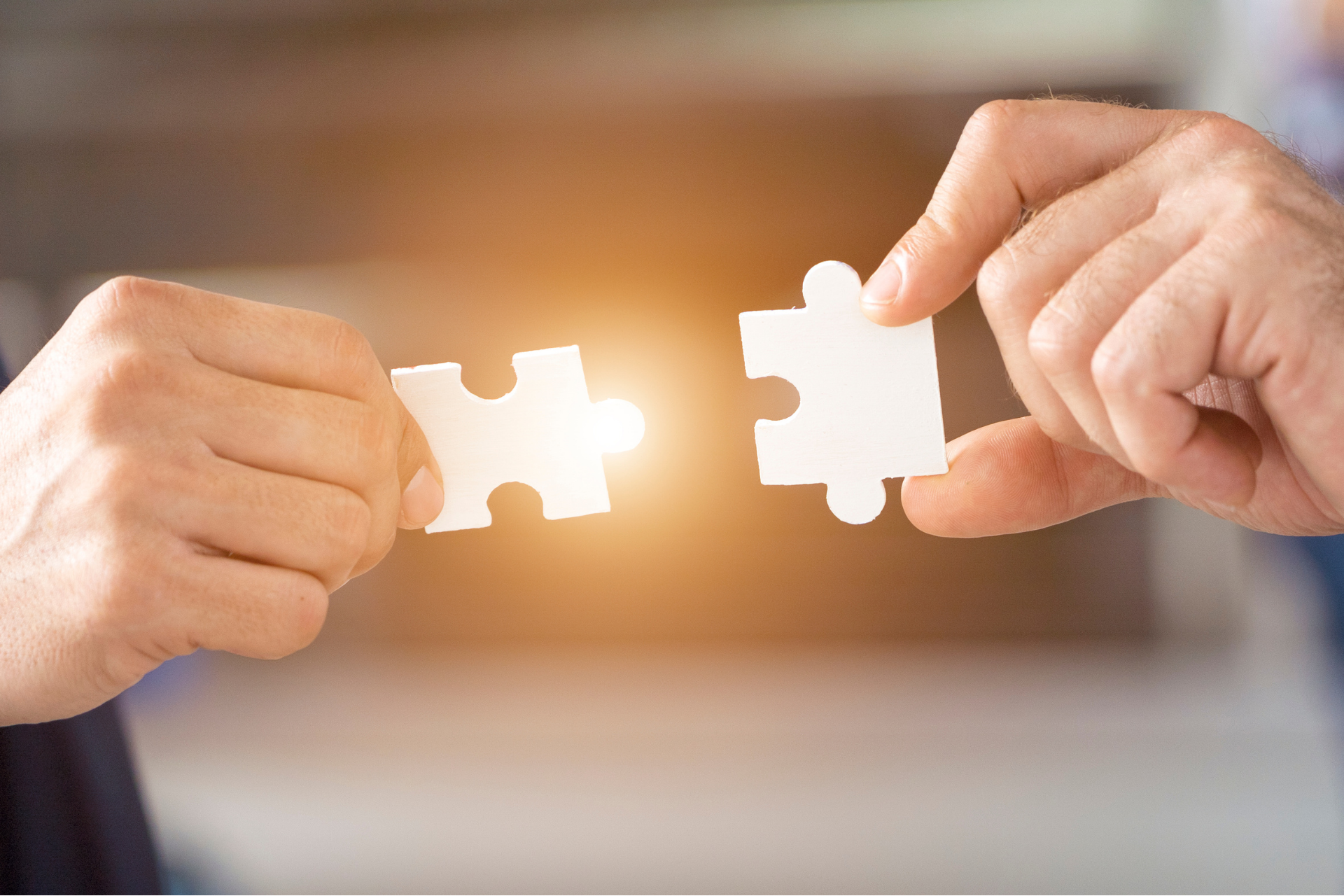 Two hands connecting puzzle pieces symbolizing integration